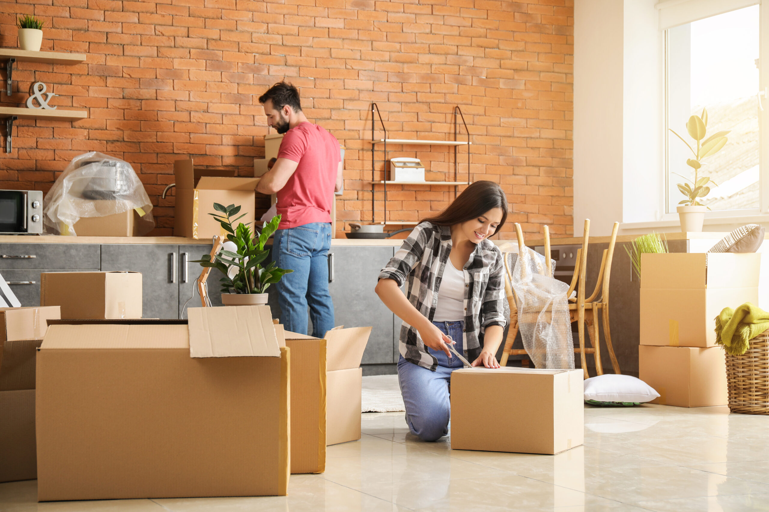 Young couple unpacking boxes on moving to new home